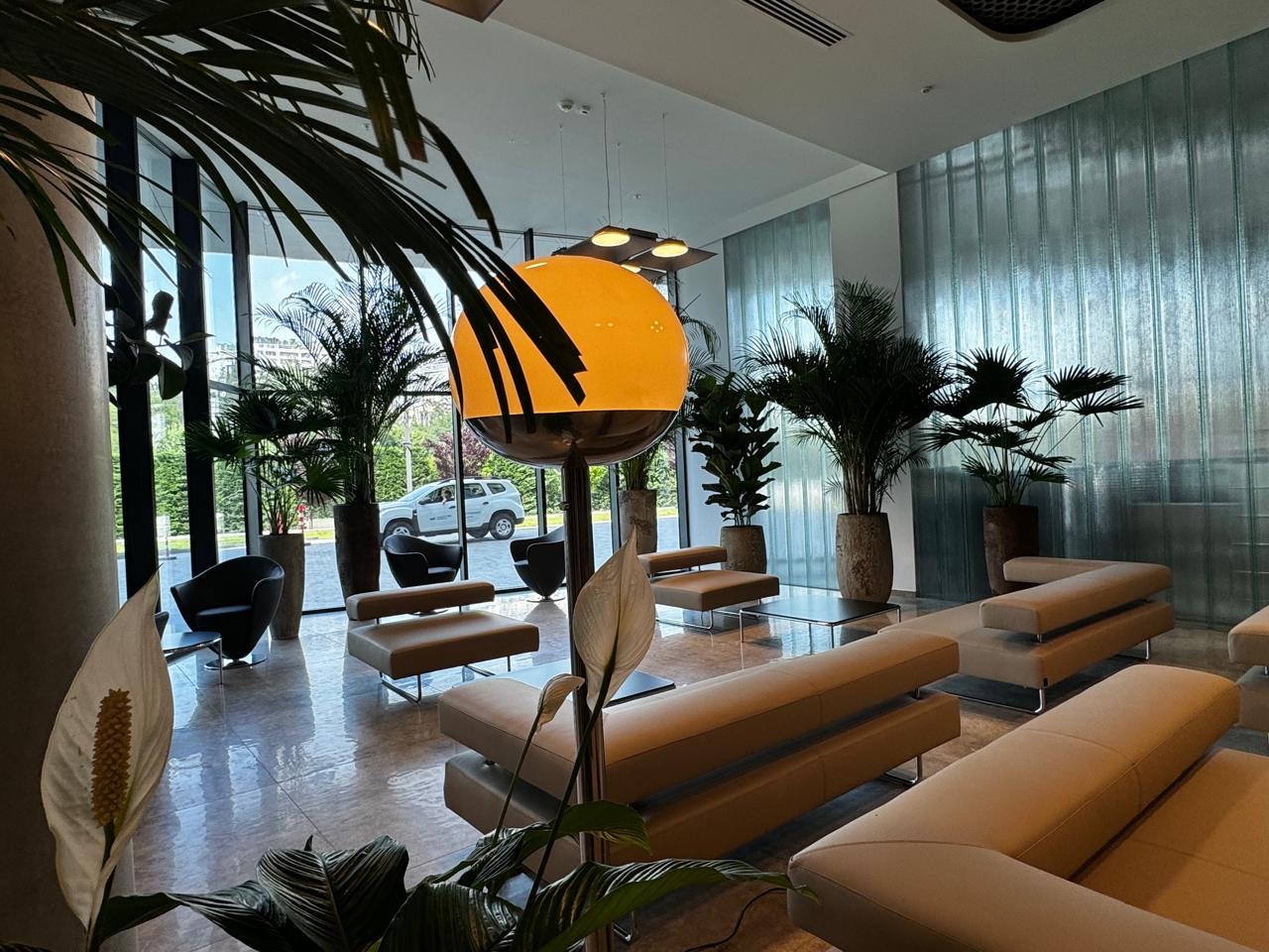Lounge with beige sofas, an orange globe lamp and a ribbed glass wall