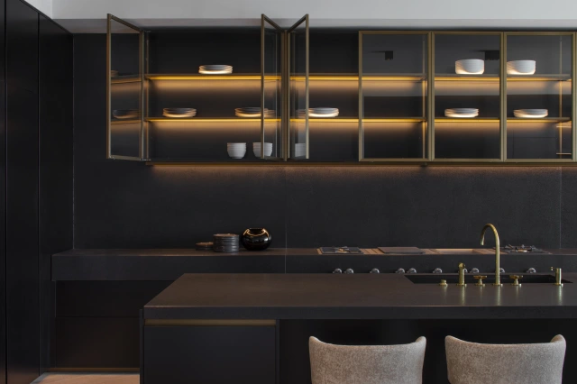 The kitchen's glass-fronted wall units in bronze