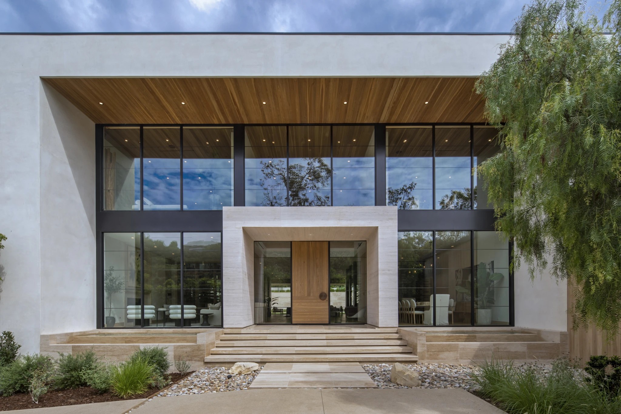 The entrance front, with a travertine portal and oak pivot door