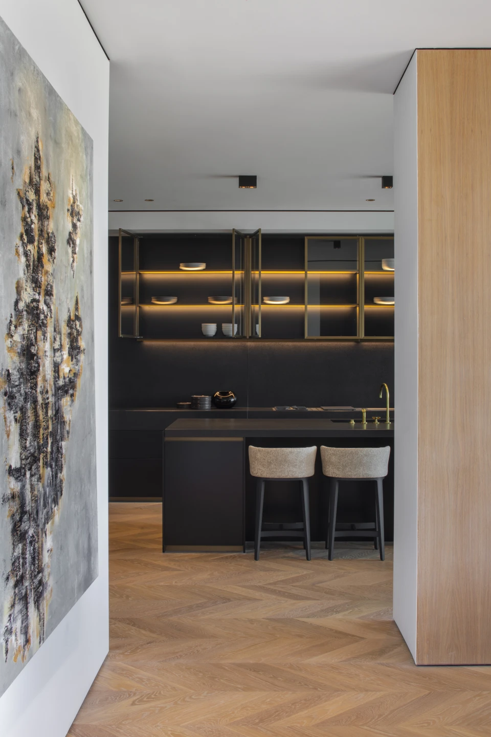 The kitchen seen from the hall, across chevron oak
